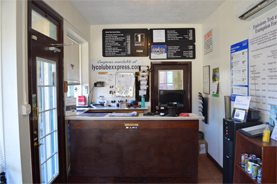 Brown wood front desk of Lyco Lube XXpress with signage, information, and other administrative tools visible in Williamsport, PA.